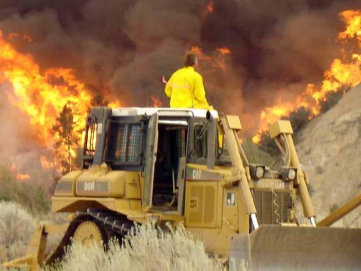 guy watching a fire from a tractor