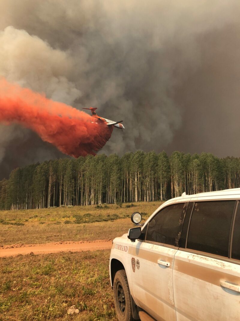 photo of plane dropping fire retardant materials on a fire